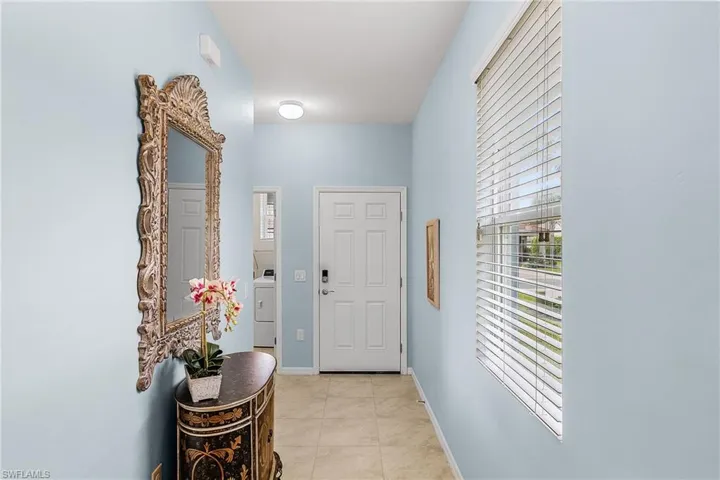 Doorway to outside with tile patterned floors and washer / clothes dryer