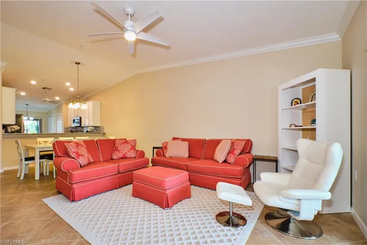 Living area featuring ornamental molding, a ceiling fan, lofted ceiling, and light tile patterned floors