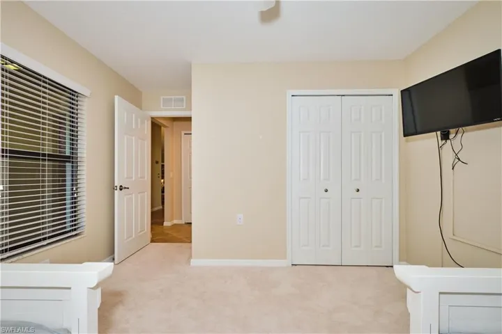 Unfurnished bedroom with light carpet and a closet