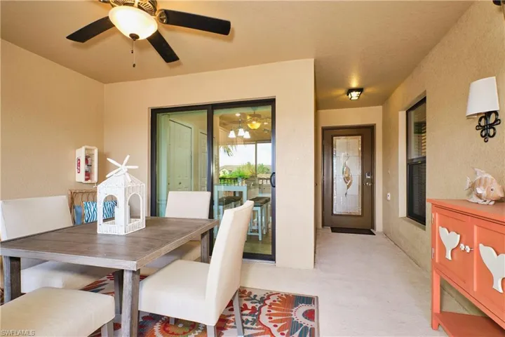 Dining area featuring light carpet, a textured wall, and a ceiling fan