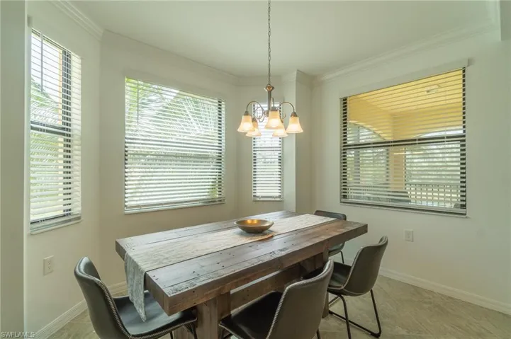 Tiled dining space with an inviting chandelier and crown molding