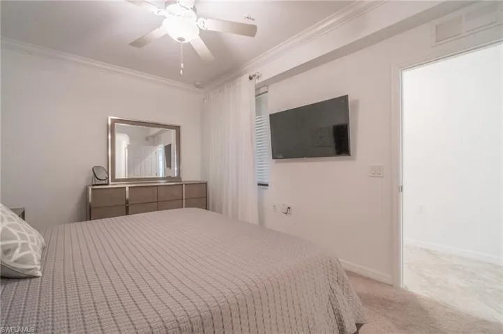 Bedroom featuring carpet, ceiling fan, and ornamental molding