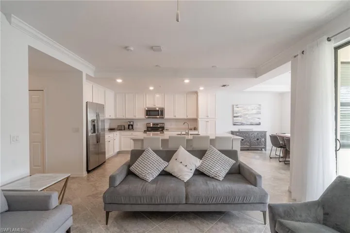 Living room featuring crown molding and light tile patterned floors