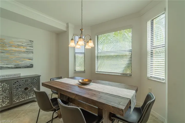 Tiled dining space with an inviting chandelier and crown molding