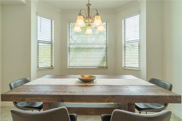 Dining space with a notable chandelier, a wealth of natural light, and crown molding