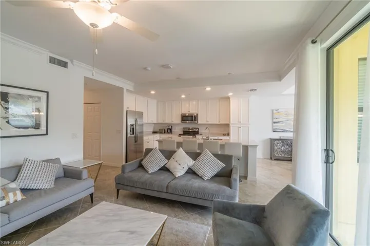 Tiled living room featuring ornamental molding, sink, and ceiling fan