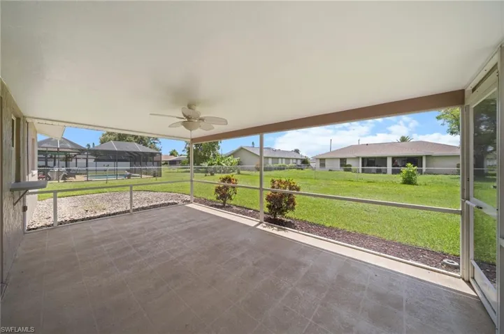 Unfurnished sunroom featuring ceiling fan and a residential view