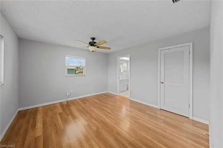 Unfurnished room featuring a textured ceiling, ceiling fan, and light wood-type flooring