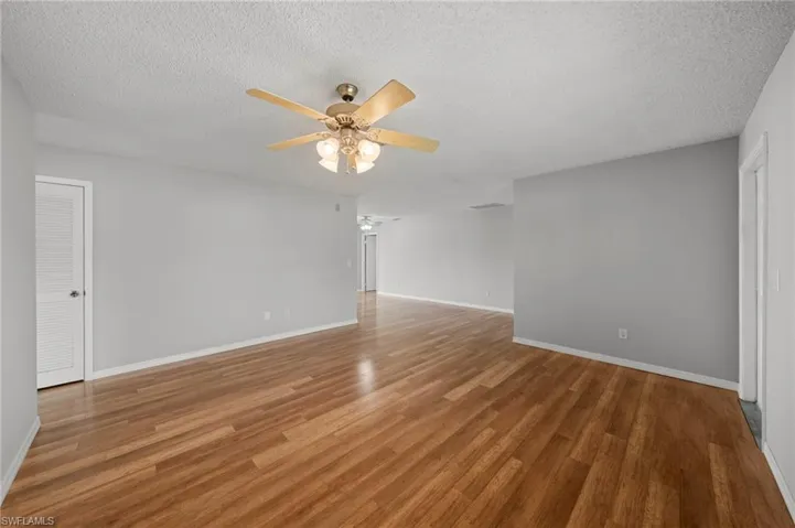 Spare room with a ceiling fan, a textured ceiling, and wood finished floors