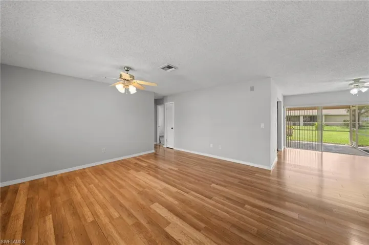 Unfurnished room with a ceiling fan, a textured ceiling, and light wood-type flooring