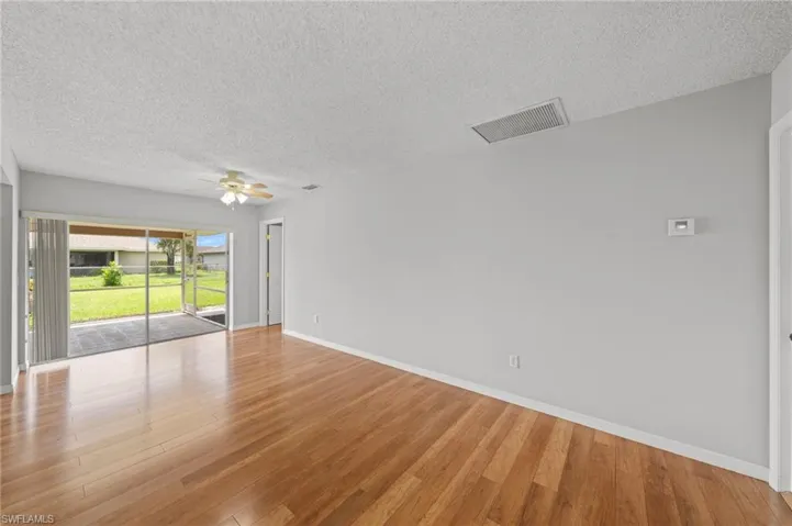 Spare room featuring a textured ceiling, wood finished floors, and a ceiling fan