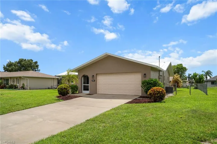Ranch-style home featuring stucco siding, an attached garage, and driveway