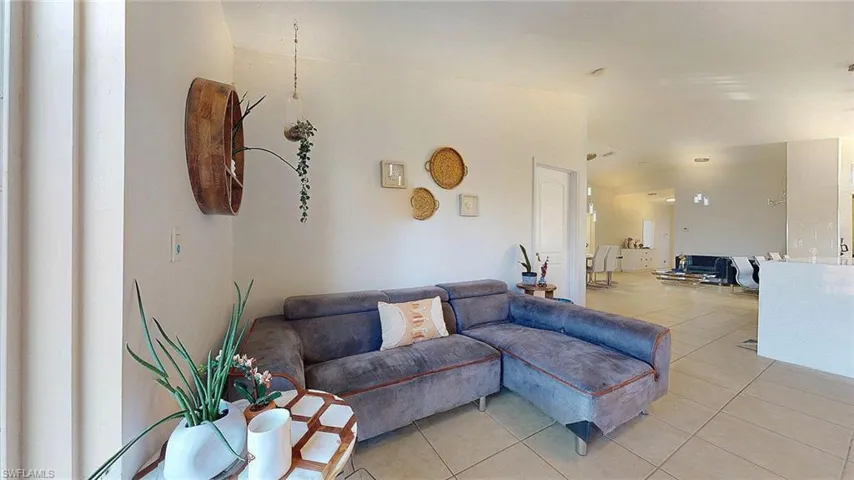 Living area with light tile patterned flooring and lofted ceiling