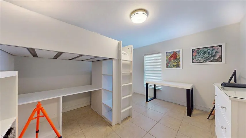 Unfurnished bedroom featuring light tile patterned floors and baseboards