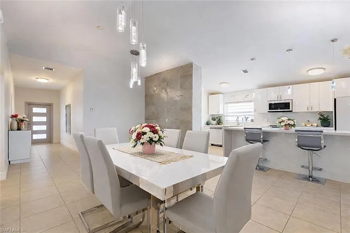 Dining space with light tile patterned flooring and lofted ceiling