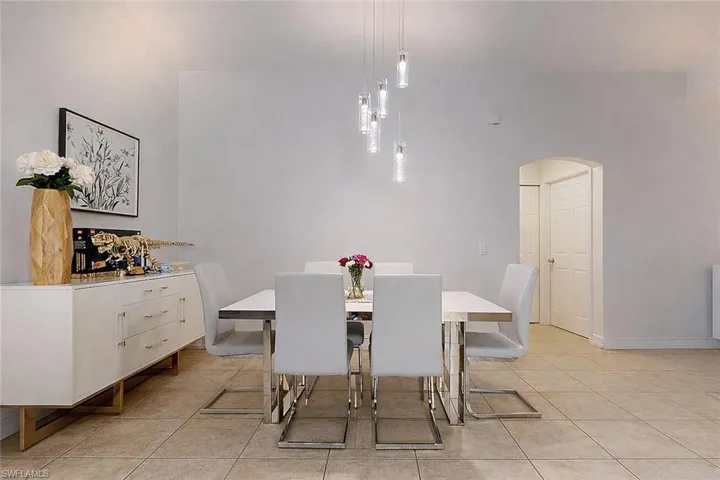 Dining area with arched walkways and light tile patterned floors