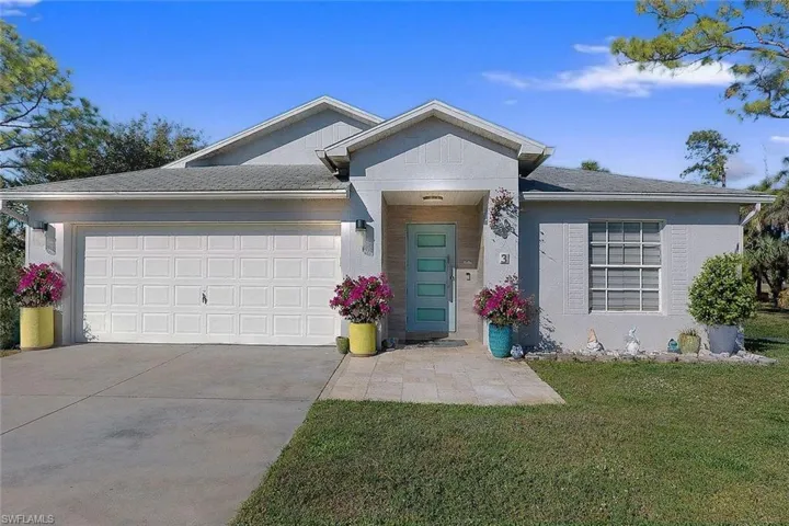 Ranch-style house featuring a front lawn, concrete driveway, roof with shingles, a garage, and stucco siding