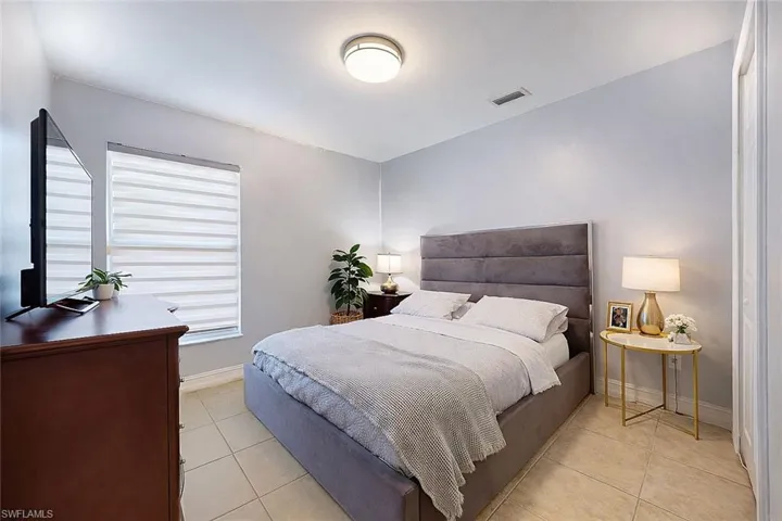Bedroom featuring light tile patterned flooring and baseboards