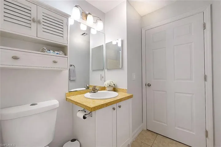 Half bathroom featuring vanity and light tile patterned floors