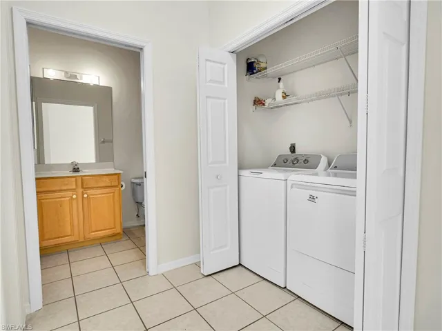 Washroom featuring washing machine and clothes dryer and light tile patterned floors