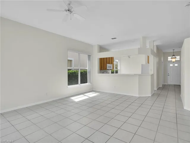 Living room with large windows and ceiling fan.
