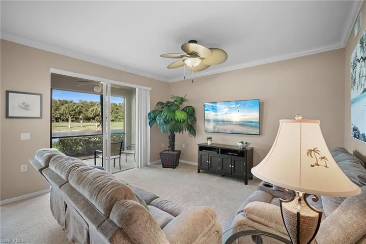 Living area with ornamental molding, carpet flooring, and ceiling fan