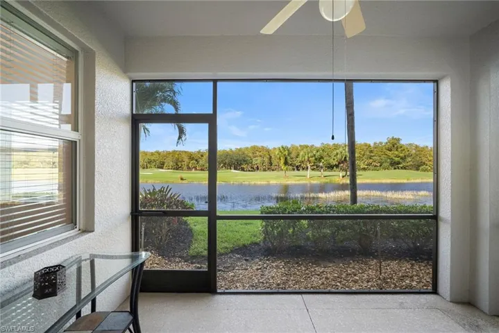 Unfurnished sunroom featuring view of scattered trees and a water view