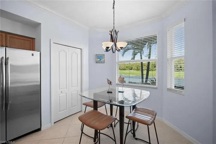 Dining room with crown molding, light tile patterned floors, and a chandelier