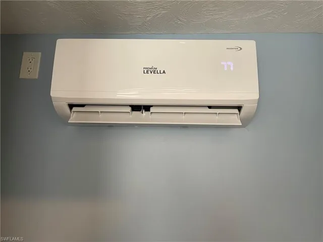 Room details featuring a textured ceiling and a wall mounted AC