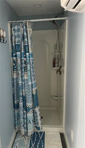 Full bath with a shower with curtain and baseboards