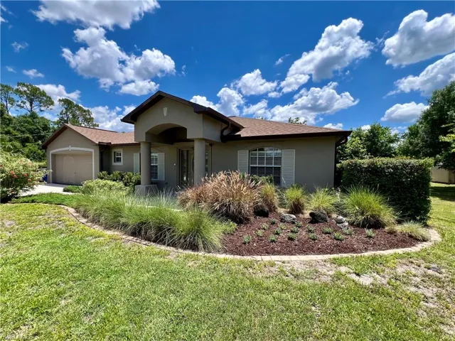 View of front facade featuring a front lawn and a garage
