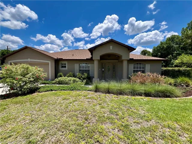 View of front of home with a garage and a front yard