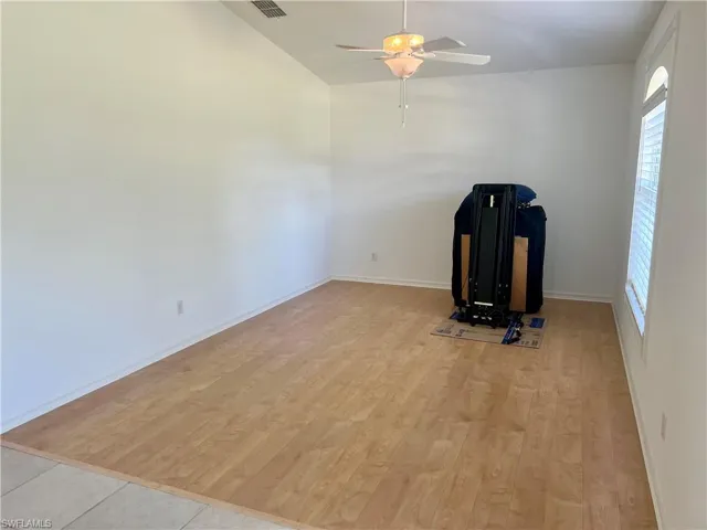 Den with ceiling fan, plenty of natural light, and light hardwood / wood-style floors