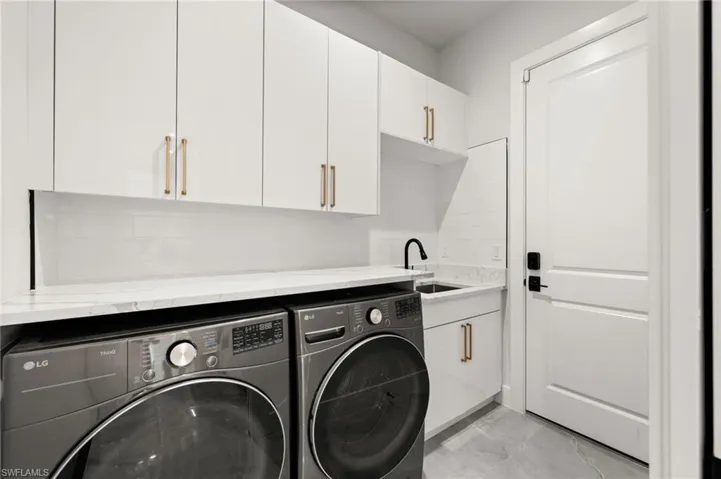 Large laundry room with sink and storage.
