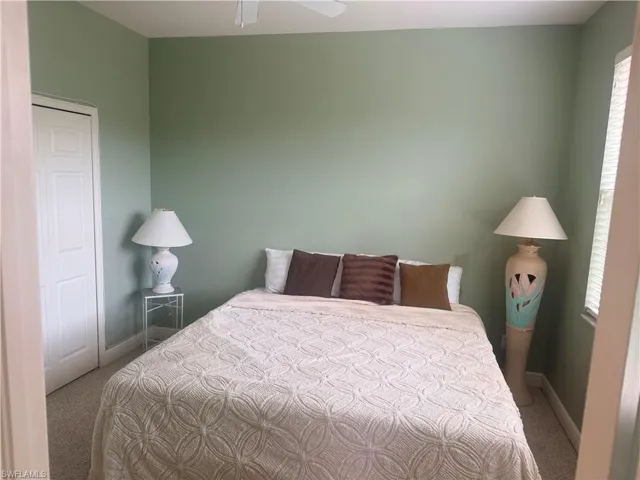 This room features light green walls and carpeted flooring