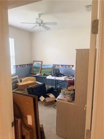 This room features a ceiling fan, carpeted flooring, and a window with blinds
