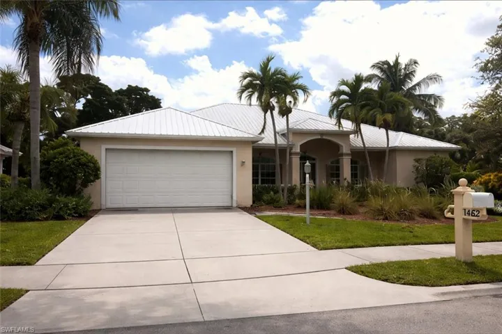 Ranch-style house featuring an attached garage, concrete driveway, stucco siding, and a front lawn