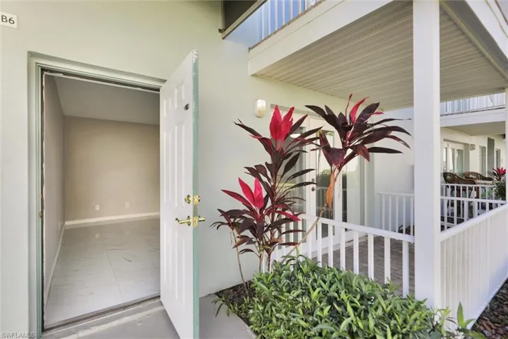 Property entrance with a porch and stucco siding