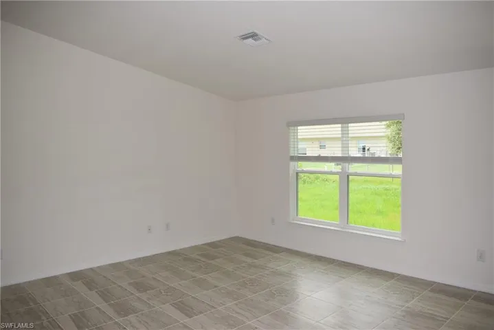 Unfurnished room with a healthy amount of sunlight and light tile patterned floors