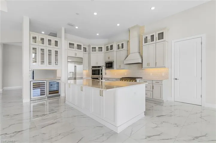 Kitchen featuring built in appliances, marble finish floor, recessed lighting, tasteful backsplash, and visible vents