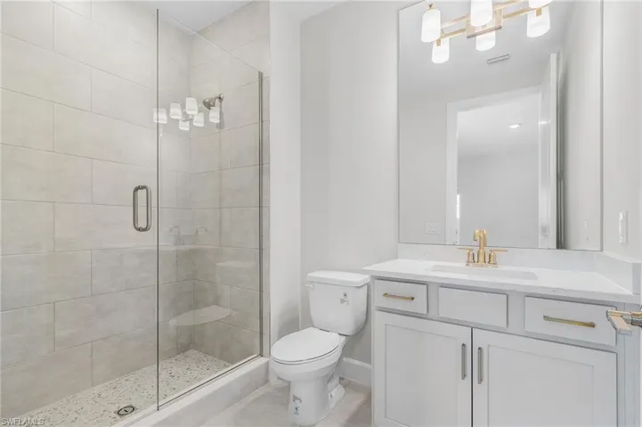 Full bathroom with vanity, tile patterned flooring, visible vents, toilet, and a stall shower