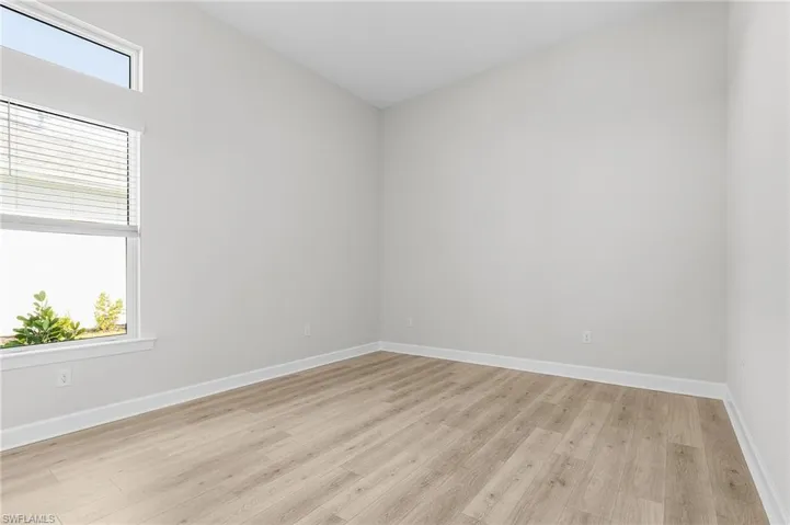 Spare room featuring baseboards and light wood finished floors