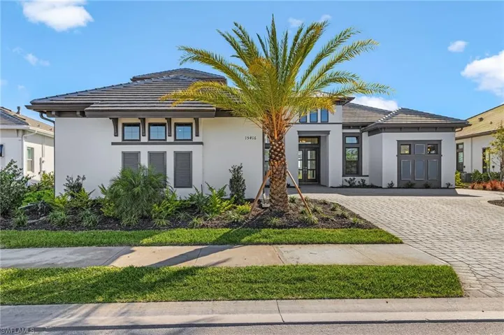 View of front of house featuring stucco siding, driveway, and a tile roof