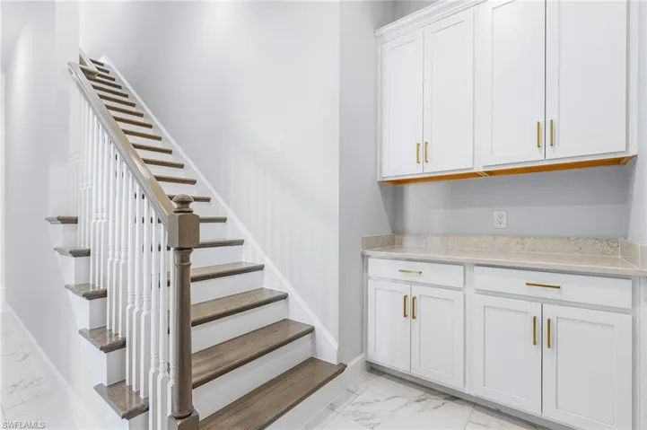 Stairs with baseboards and marble finish floor