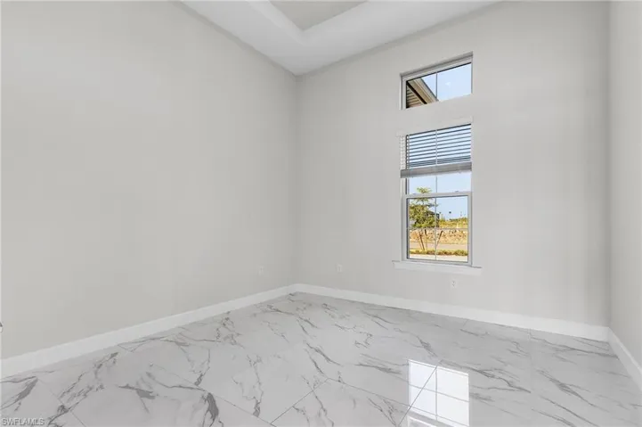 Empty room featuring baseboards and marble finish floor