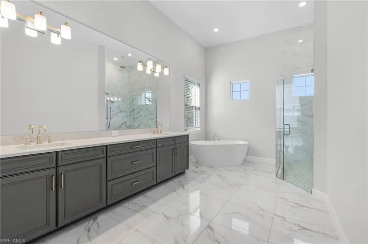 Full bath featuring a marble finish shower, a sink, and marble finish floor