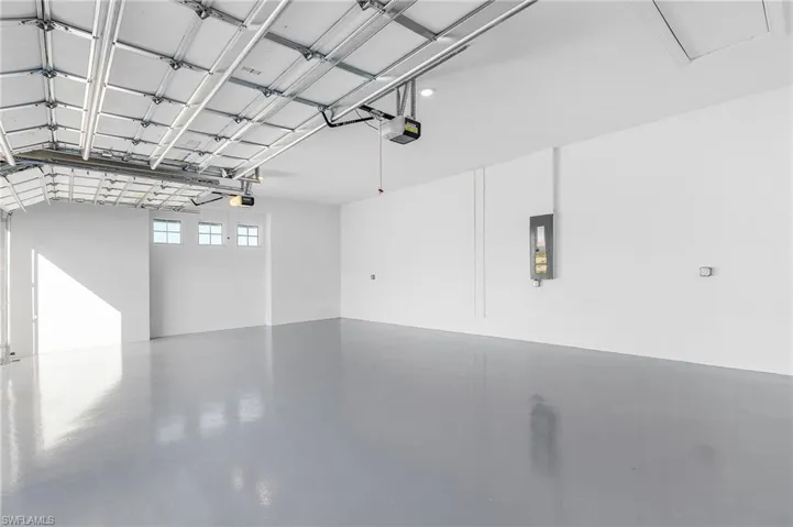 Garage featuring a garage door opener and electric panel