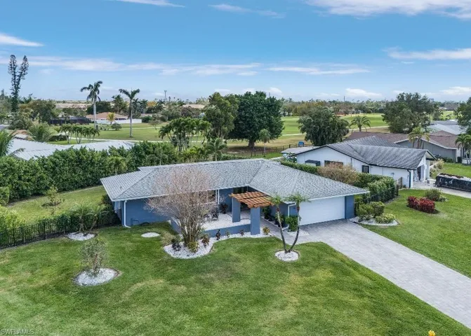 View of front facade featuring a garage, decorative driveway, and view of golf course
