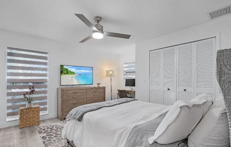 Bedroom with wood finished floors, ceiling fan, a closet, and a textured ceiling