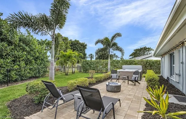 Fenced backyard featuring a hot tub, a patio area, and an outdoor fire pit